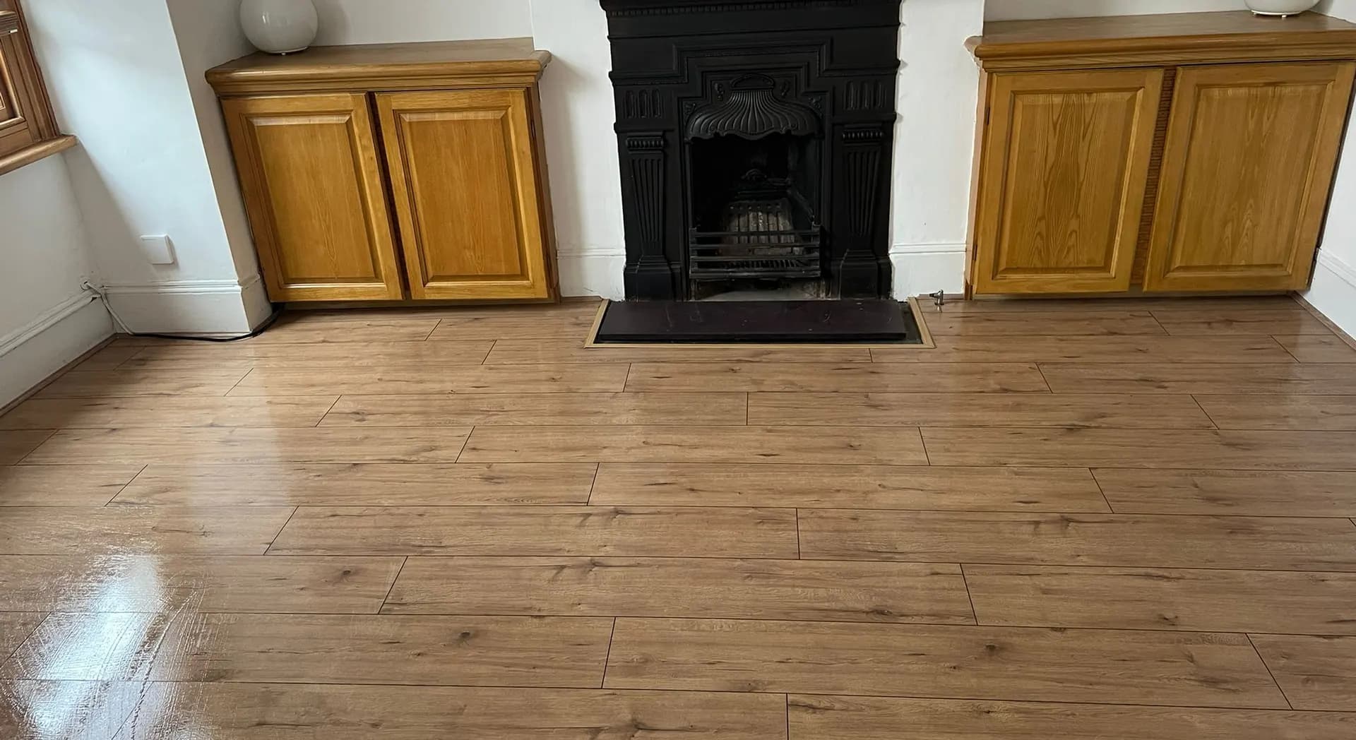 Freshly cleaned wooden floor and period fireplace in a family home